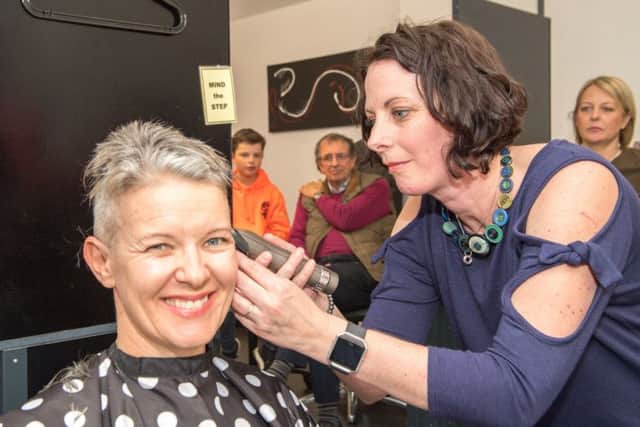 Almost there... close shave as Jane's head shave is nearly finished. Picture: John Aron.