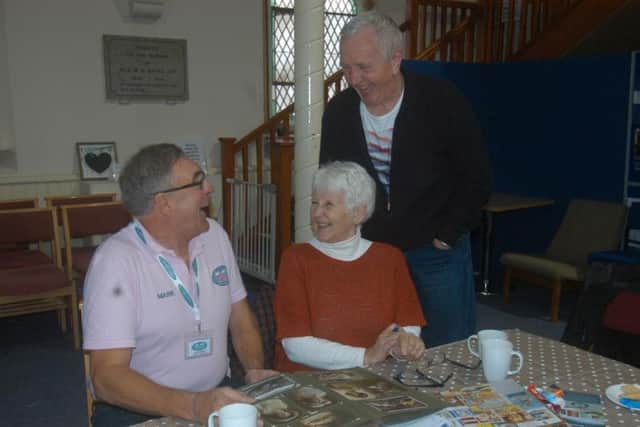 Mark Bamford of Sleaford Museum Trust looking through an album with Ann and Martyn Shearing.