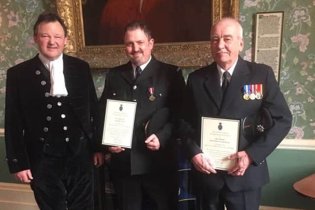 PCSO Nigel Wass and Alan Maskell with their awards.