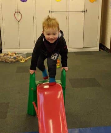 Yippee... Tots take to the slide at the group.