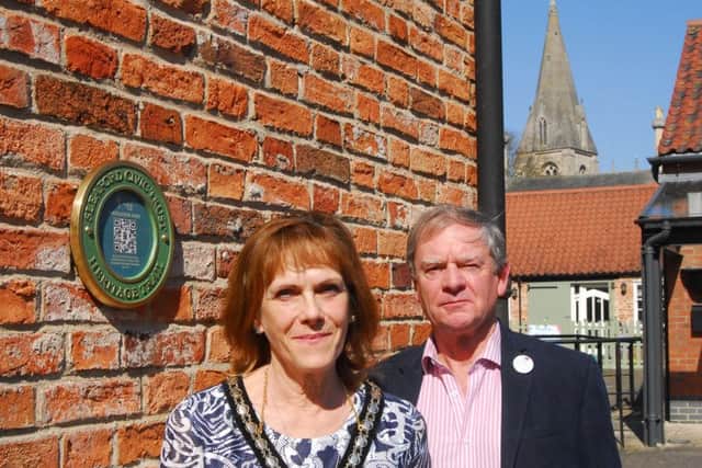 Mayor of Sleaford, Coun Jan Mathieson and chairman of Sleaford and District Civic Trust Garry Titmus unveil the first interactive heritage trail plaque on the Town Hall. EMN-180420-170345001