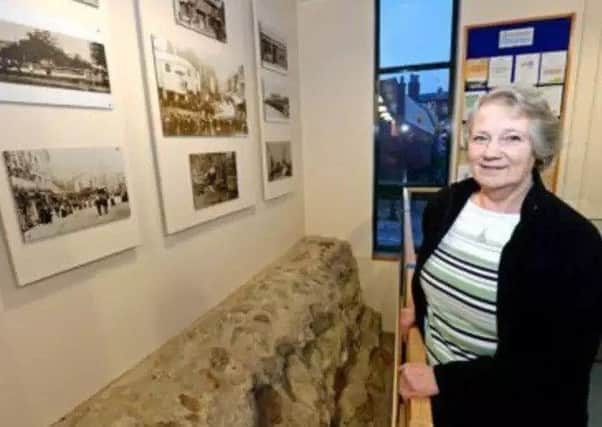Sheila Jonkers in front of a section of the Roman wall in Horncastle Library. EMN-180418-101553001