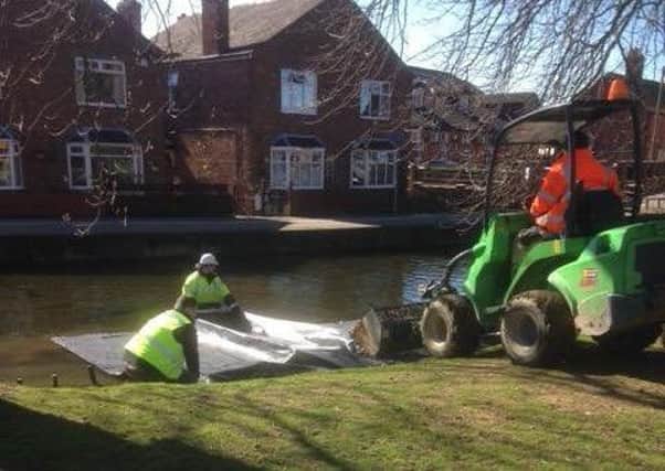 Sleaford Town Council staff and contractors setting up the coir roll matting to reinstate the river bank. EMN-180420-101641001