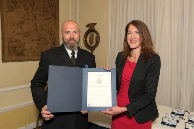 Pc James Perring reciving his award from Rachel Watson. EMN-180425-174248001
