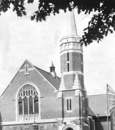Crowds gather outside the church in this historic picture - perhaps of a wedding scene or after a service.