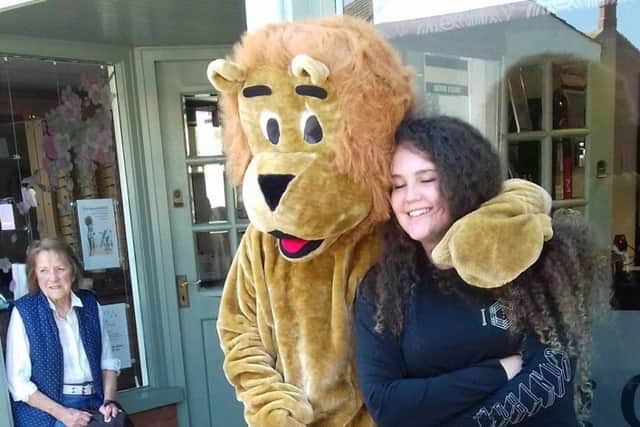 Roar-some... Amber cuddles a Lion mascot before her hair cut. EMN-181005-114455001