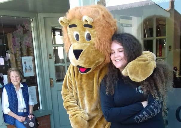 Roar-some... Amber cuddles a Lion mascot before her hair cut. EMN-181005-114455001