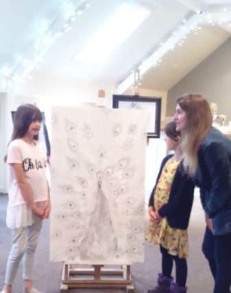 A drawing of an ostrich attracted the attention of sisters Eren and Taya, pictured at the exhibition with their mother Coral. EMN-180514-102244001