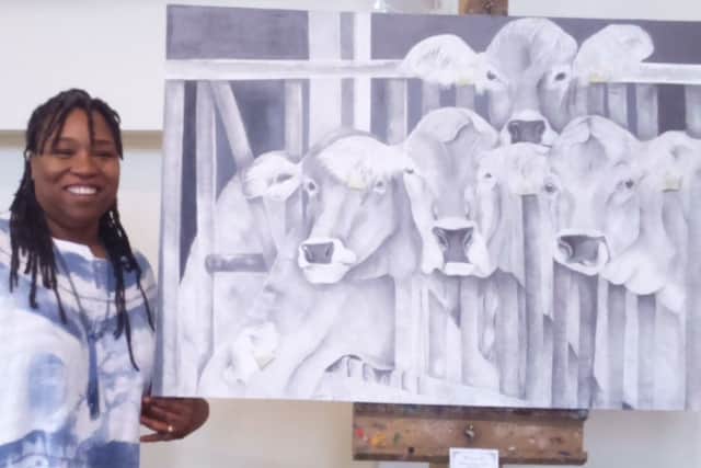 What a moo-ving piece - Anita Mortimer poses with a drawing of some cows at the exhibition. EMN-180514-102255001