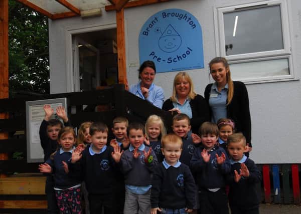 Brant Broughton Pre-School children celebrate a good Ofsted inspection rating with, from left - Michelle O'Reilly - deputy manager, Sally Harper - manager and Emily Harper - Pre-school Practitioner. EMN-180520-104359001