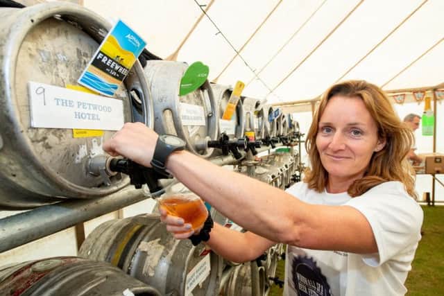 Thirsty work... Committee member Alsion Lauder pulling pints. EMN-180528-114316001