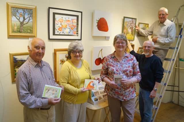 Painting group members Brian Oxborrow, Caroline Foster and Kate Roberts get help to mount their exhibits from two of the centres volunteers. EMN-180406-081011001
