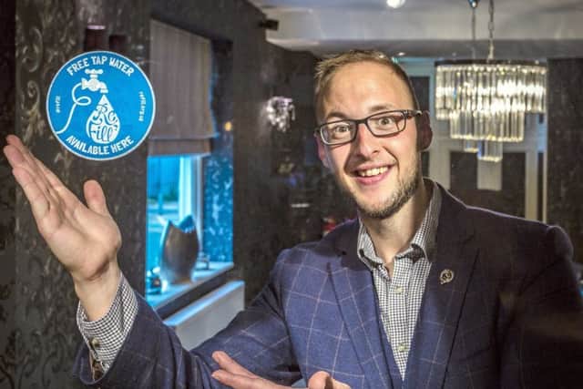 Adam Charity, Operations Manager, with the sticker which will be displayed The Admiral Rodney.