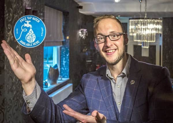 Adam Charity, Operations Manager, with the sticker which will be displayed The Admiral Rodney.