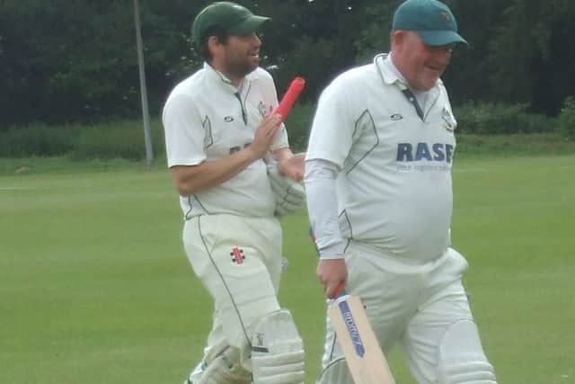 Ian Williams (right) and Neil Davies walk off at the end of the record-breaking innings EMN-180618-155541002