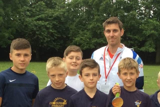 GB athlete Richard Buck with Osbournby School children. EMN-180622-114303001