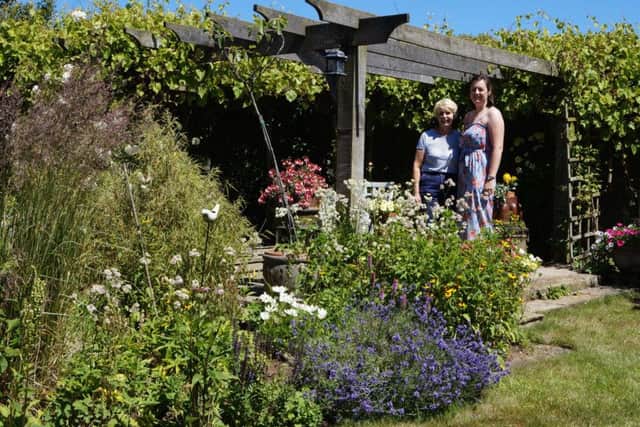 Award-winning garden: Catherine Marris, left, whose garden won the Caistor in Bloom award in 2012 and 2014, pictured with Holly Marris. EMN-180107-211752001
