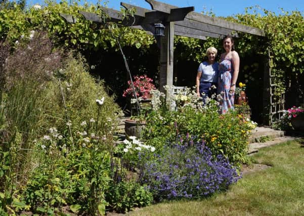 Award-winning garden: Catherine Marris, left, whose garden won the Caistor in Bloom award in 2012 and 2014, pictured with Holly Marris. EMN-180107-211752001