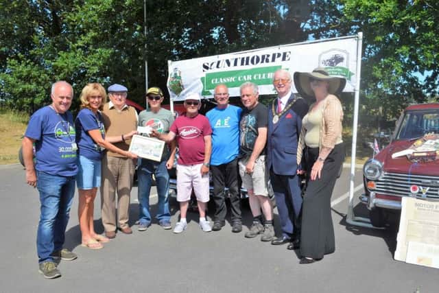 Mayor of North Lincolnshire Cllr John Briggs (second right) and Mayoress Joanne Brown (right) watch on as members of Scunthorpe Classic Car Club are pictured presenting their cheque for Â£200 to Lindsey Lodge Hospice Chief Executive Karen Griffiths (second left) and Fundraiser Andy Hirst (left). EMN-180707-091051001