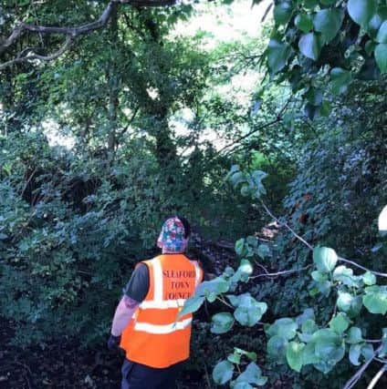Sleaford Town Council staff getting stuck in clearing rubbish from a boundary ditch at Castlefield. EMN-180907-114123001