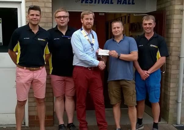 Market Rasen Round Table chairman Paddy Cameron handed the cheque to Youth Club  treasurer Bruce Davies, watched by Round Table members. EMN-180723-150015001