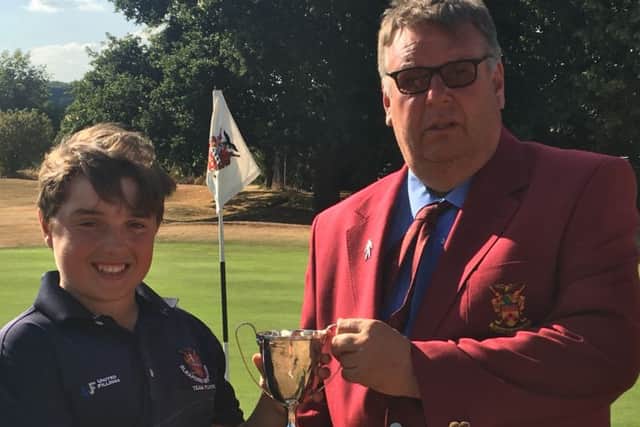 Michael receives the Sleaford Golf Club men's champion trophy from club captain Ian Addlesee EMN-180719-145117002