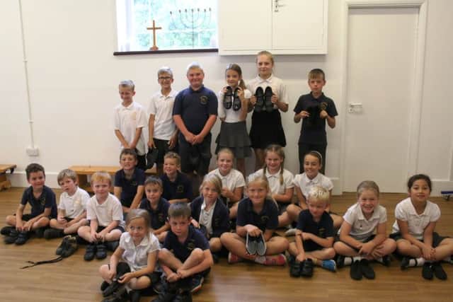 These other youngsters are all smiles before handing over their donated shoes to Sals Shoe Project.