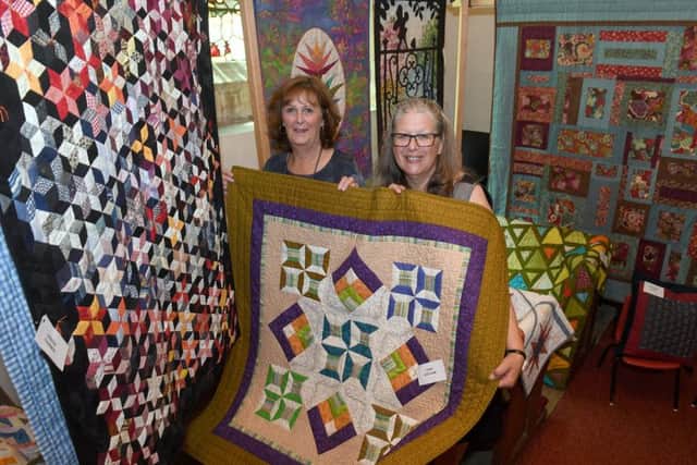Exhibition of textiles at Cranwell Village Hall and Church. L-R Sandra Berry and Rosie Lundgren with traditional quilts in the church. EMN-180723-103335001