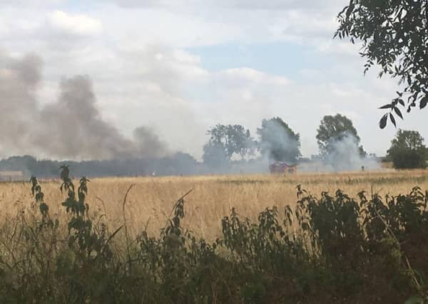 Firefighters tackling the field fire seen from Orchard Close in Great Hale. Photo by Beth Robinson. EMN-180725-162200001