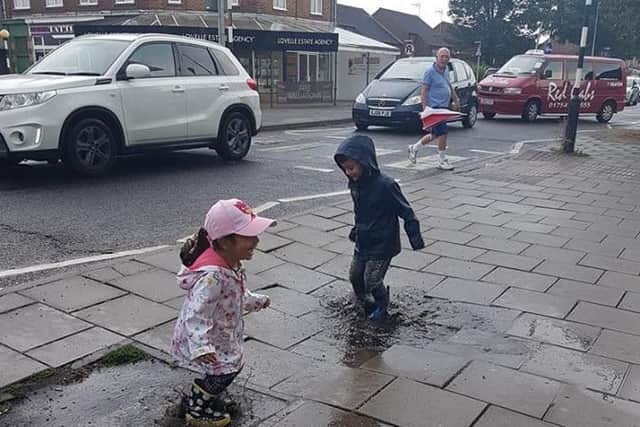 The storms may have brought misery for some but these children still found a way to have fun. Photo: Barry Robinson.. ANL-180728-084256001