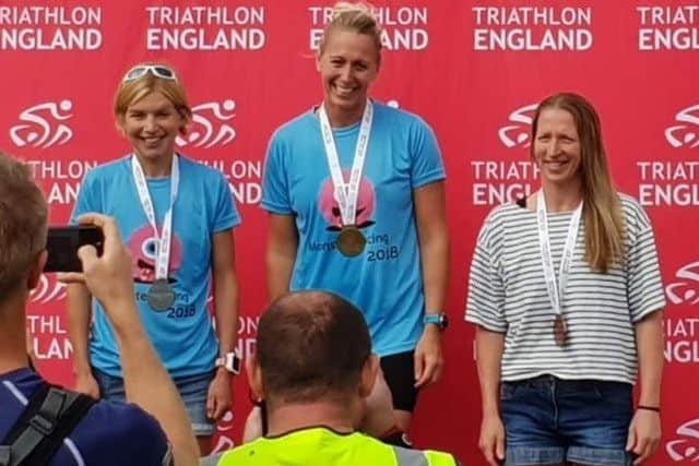 Harriet (left) climbs the podium for her age group EMN-180608-121321002