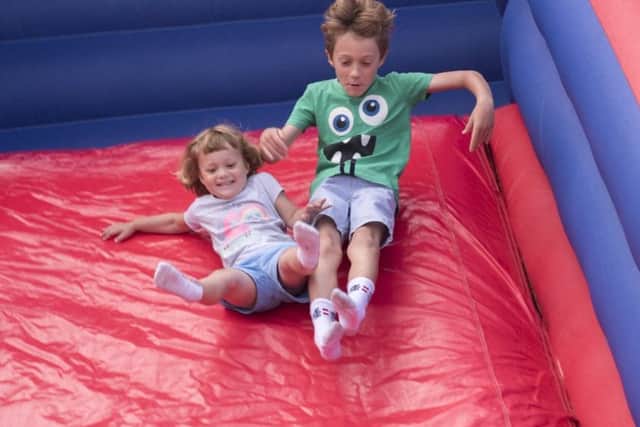 Felix, seven and Uli Bateman, three, coming down the inflatable slide.