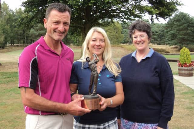 Paul and Angela Moore receive the J & J Brown Trophy from club director Jane Salt EMN-180813-093803002