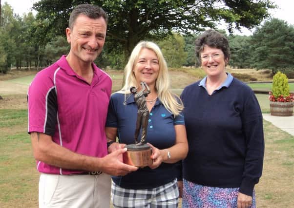 Paul and Angela Moore receive the J & J Brown Trophy from club director Jane Salt EMN-180813-093803002