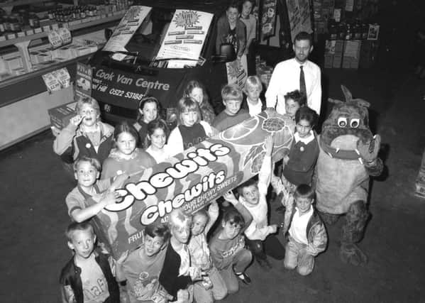 Youngsters in Boston beating the summertime blues at Booker cash and carry this week in 1993, helped by a giant pack of Chewits and a dinosaur.