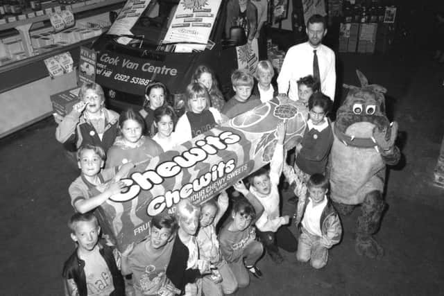 Youngsters in Boston beating the summertime blues at Booker cash and carry this week in 1993, helped by a giant pack of Chewits and a dinosaur.