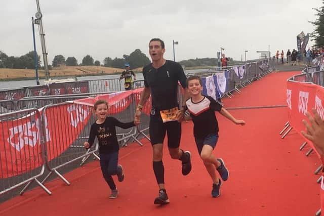 The iron doctor ... GP Chris Cope crosses the line with children Esme and Caleb.