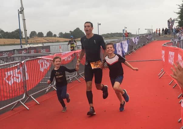 The iron doctor ... GP Chris Cope crosses the line with children Esme and Caleb.
