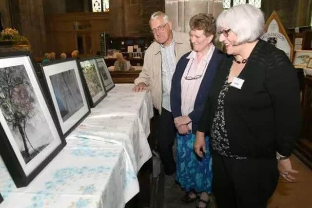 Bill Machin, Chris Cullen and Mary Rudkin looking at a display in Heckington Church at a previous open days festival. EMN-180829-155727001