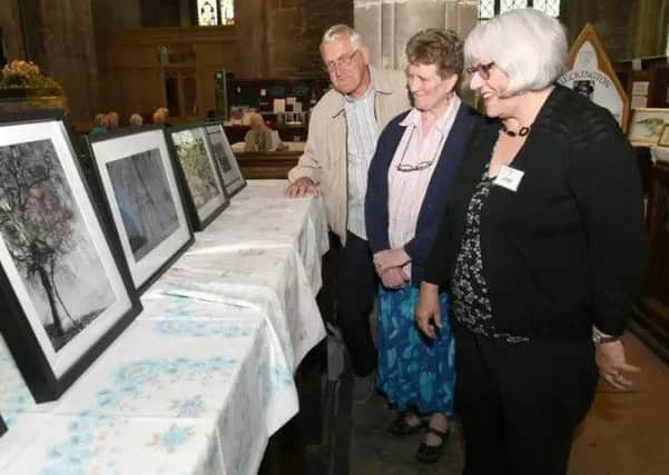 Bill Machin, Chris Cullen and Mary Rudkin looking at a display in Heckington Church at a previous open days festival. EMN-180829-155727001