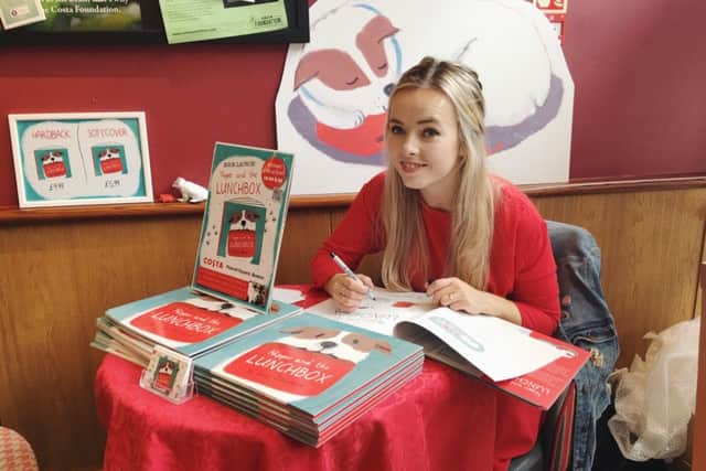 Author and illustrator Lucy Dillamore with her debut picture book Nipper and the Lunchbox.