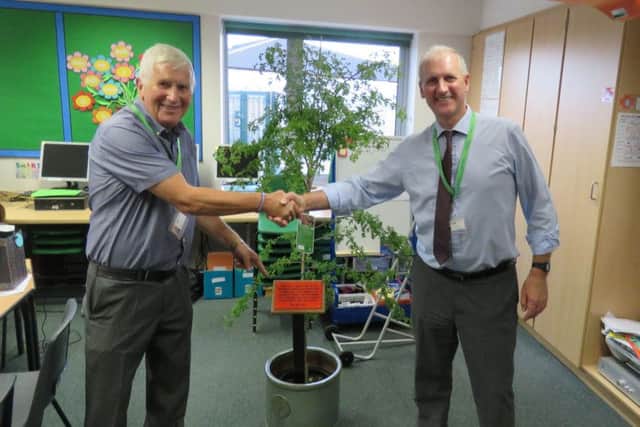 Mr Lister (right) accepts the gift of a Hawthorn Tree from the chair of Governors John Poucher.