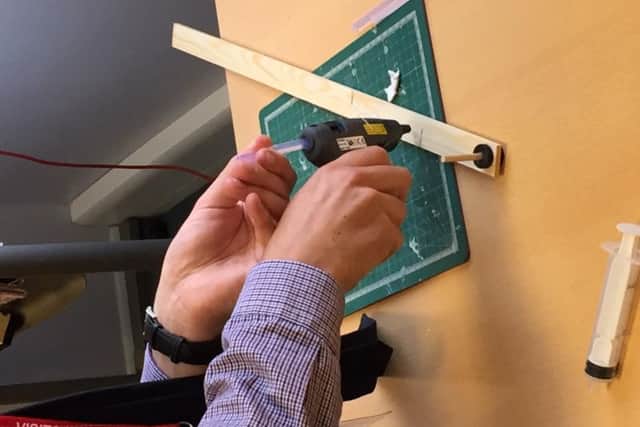 One of the teachers assembling the mechanism for their structure