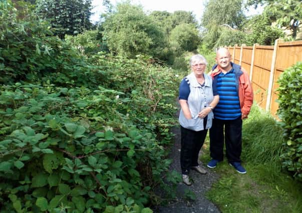 Philip Freestone and Brenda Griffiths alongside the overgrown footpath at the rear of  Thomas Gibson Way