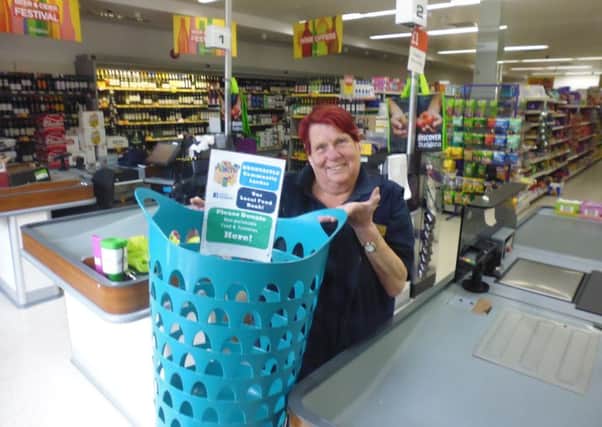 Jan Pierce, a member of staff at Budgens  in Woodhall Spa, displays the new collection basket. Picture: Bob Wayne.