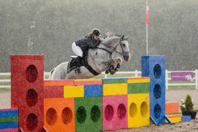 Sammi Hardy on her way to victory in the novice puissance as the rain pours Picture: Lew's Photography EMN-180919-172832002