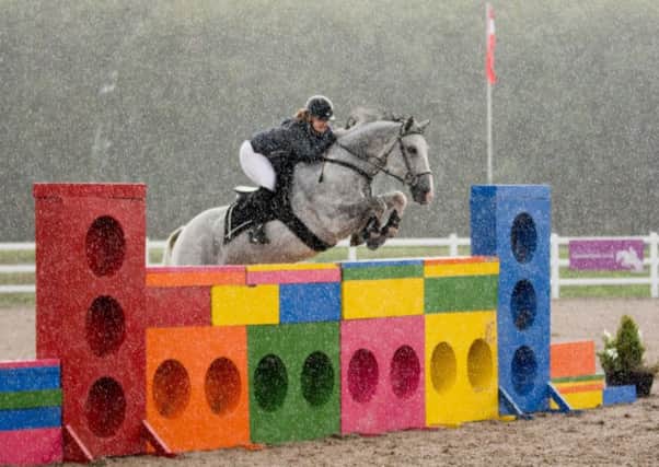 Sammi Hardy on her way to victory in the novice puissance as the rain pours Picture: Lew's Photography EMN-180919-172832002