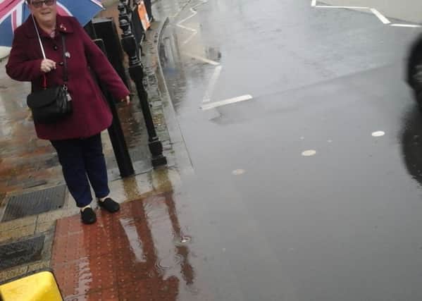 Councillor Lakin-Whitworth at the puddle which is a perpetual problem at the market place crossing
