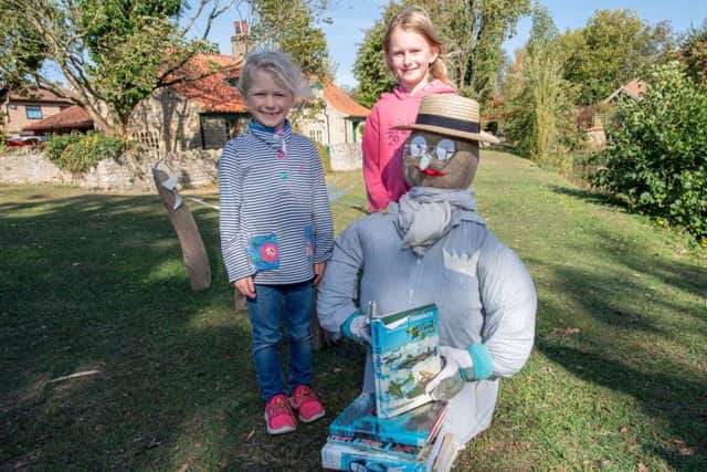 Jazmine Chappell, aged eight, and Hollie Chappel, aged 6, with the book worm scarecrow next to the Book Exchange. EMN-180110-123522001