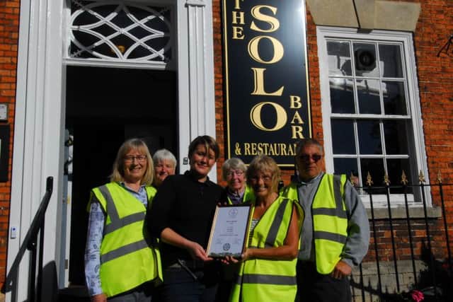 Sleaford In Bloom members present Sophie Hatcher of the Solo Bar with the East Midlands in Bloom silver award for best hotel and pub garden display. EMN-180928-093745001
